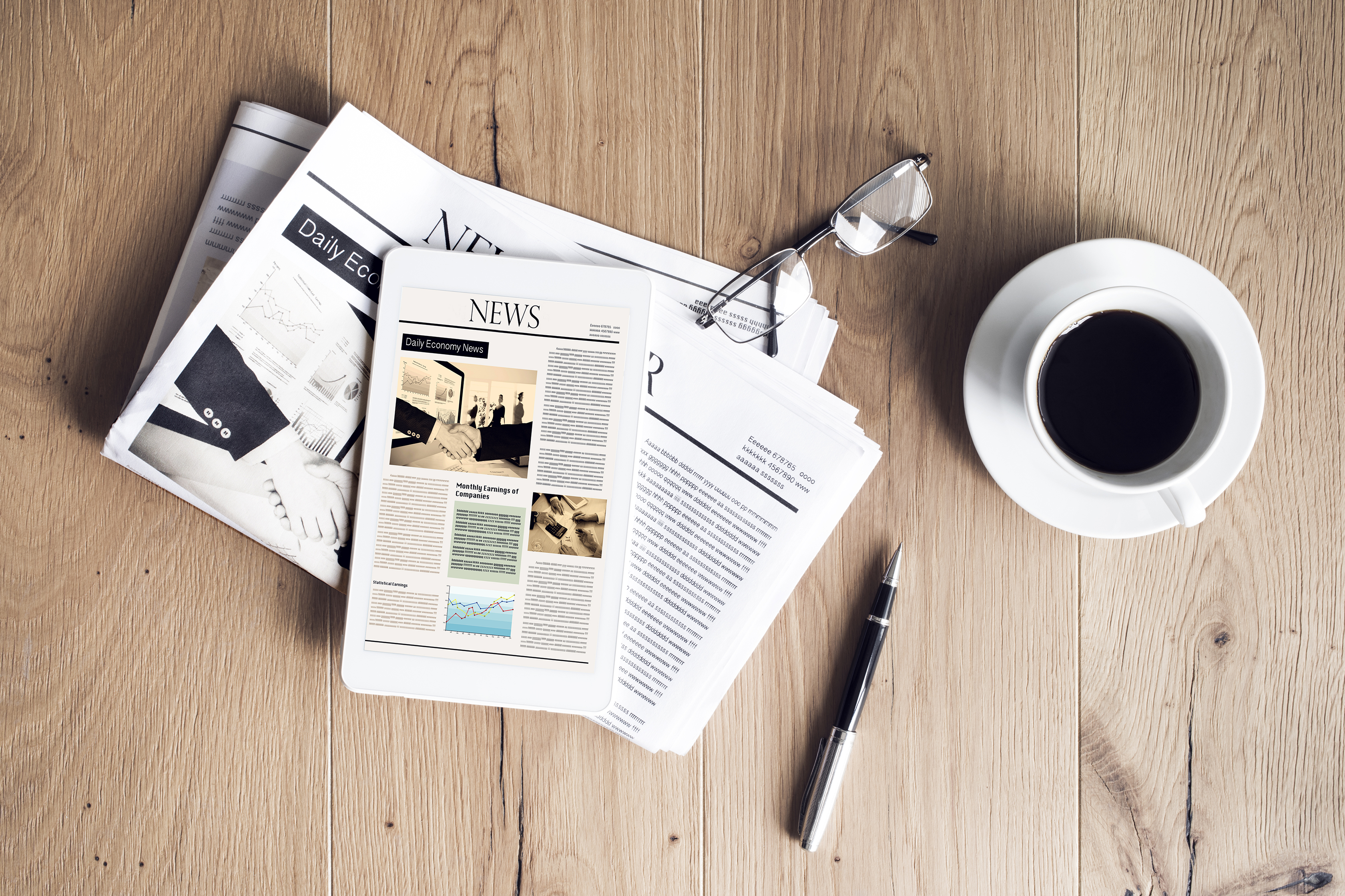 Das Bild zeigt Zeitungen, eine Tasse Kaffee und einen Stift.